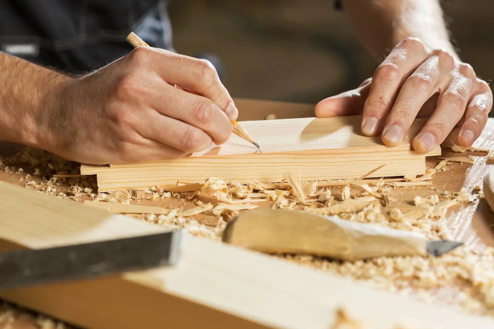 A joiner marking a length of timber with a pencil